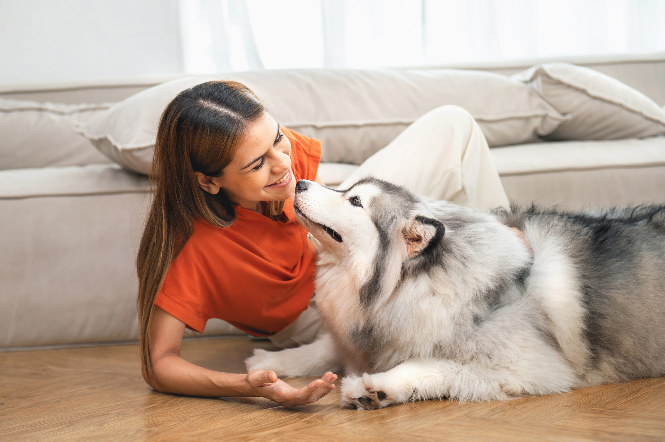 woman laying on the floor with a dog