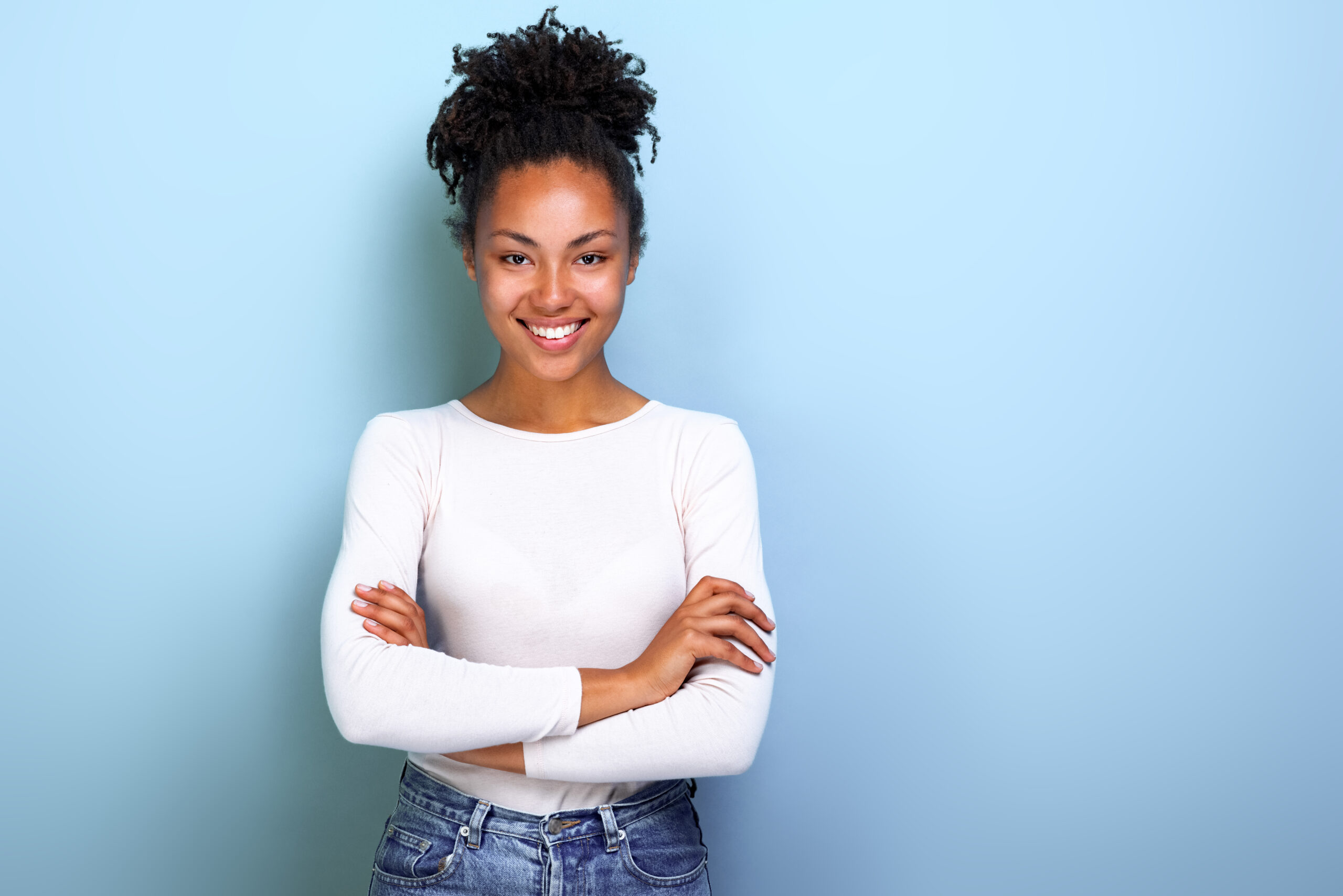 smiling woman standing with arms folded