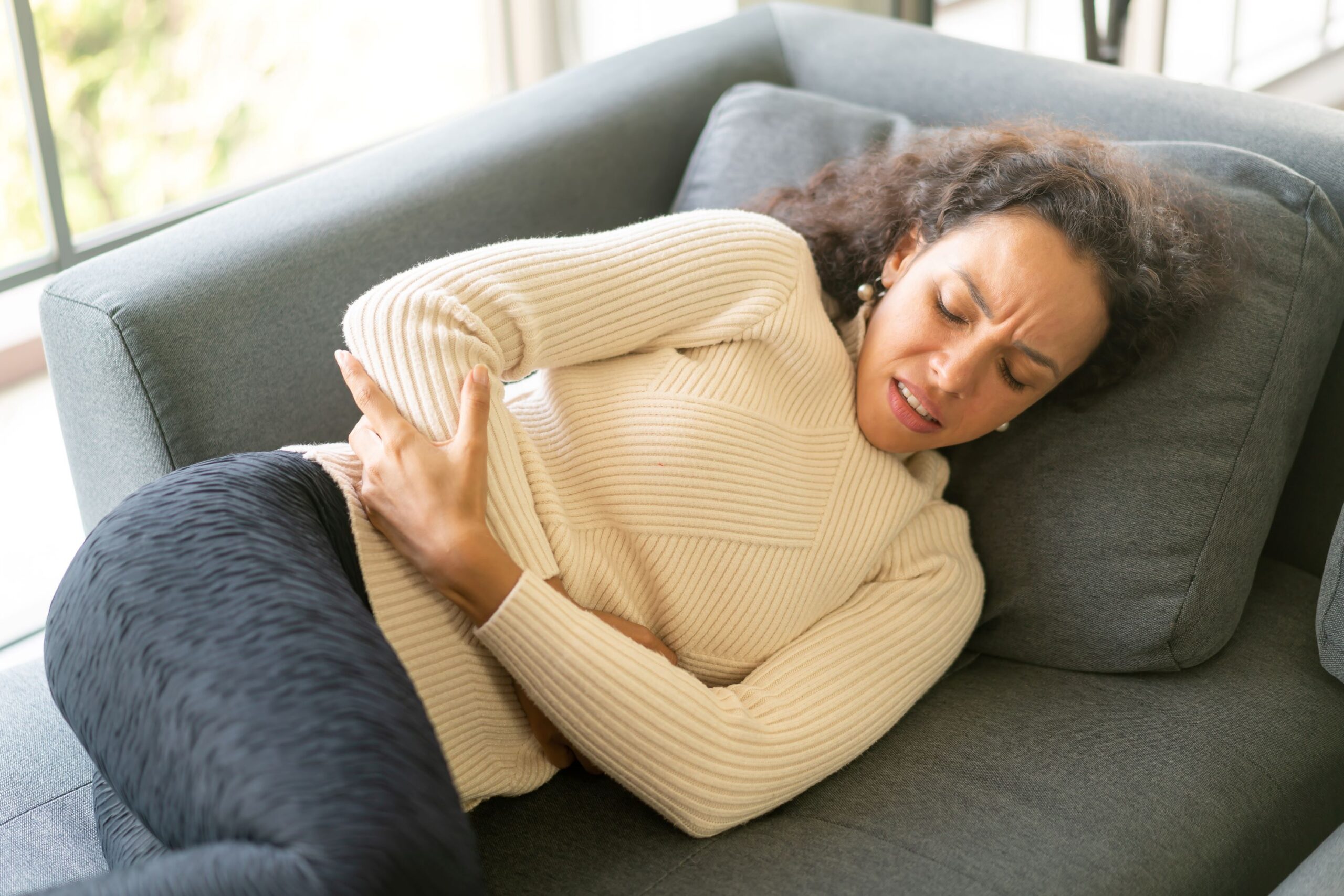 woman holding her stomach in discomfort
