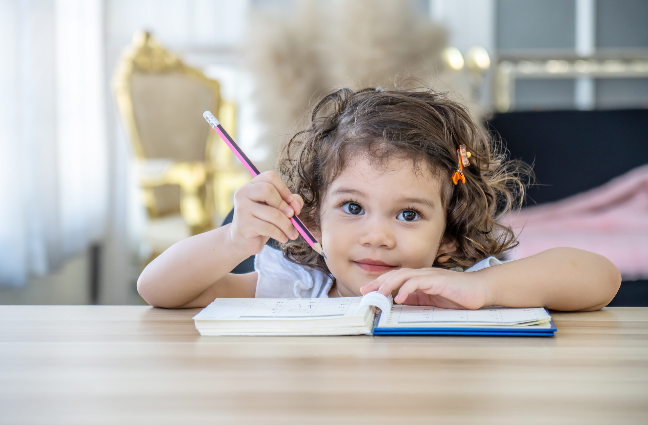 Cute little girl sit at desk at home doing homework