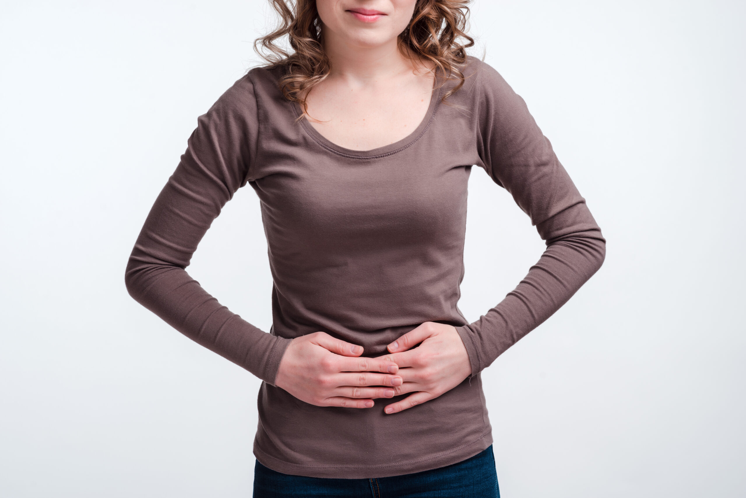 Young girl with abdominal pain close up, stomach pain clutching her stomach