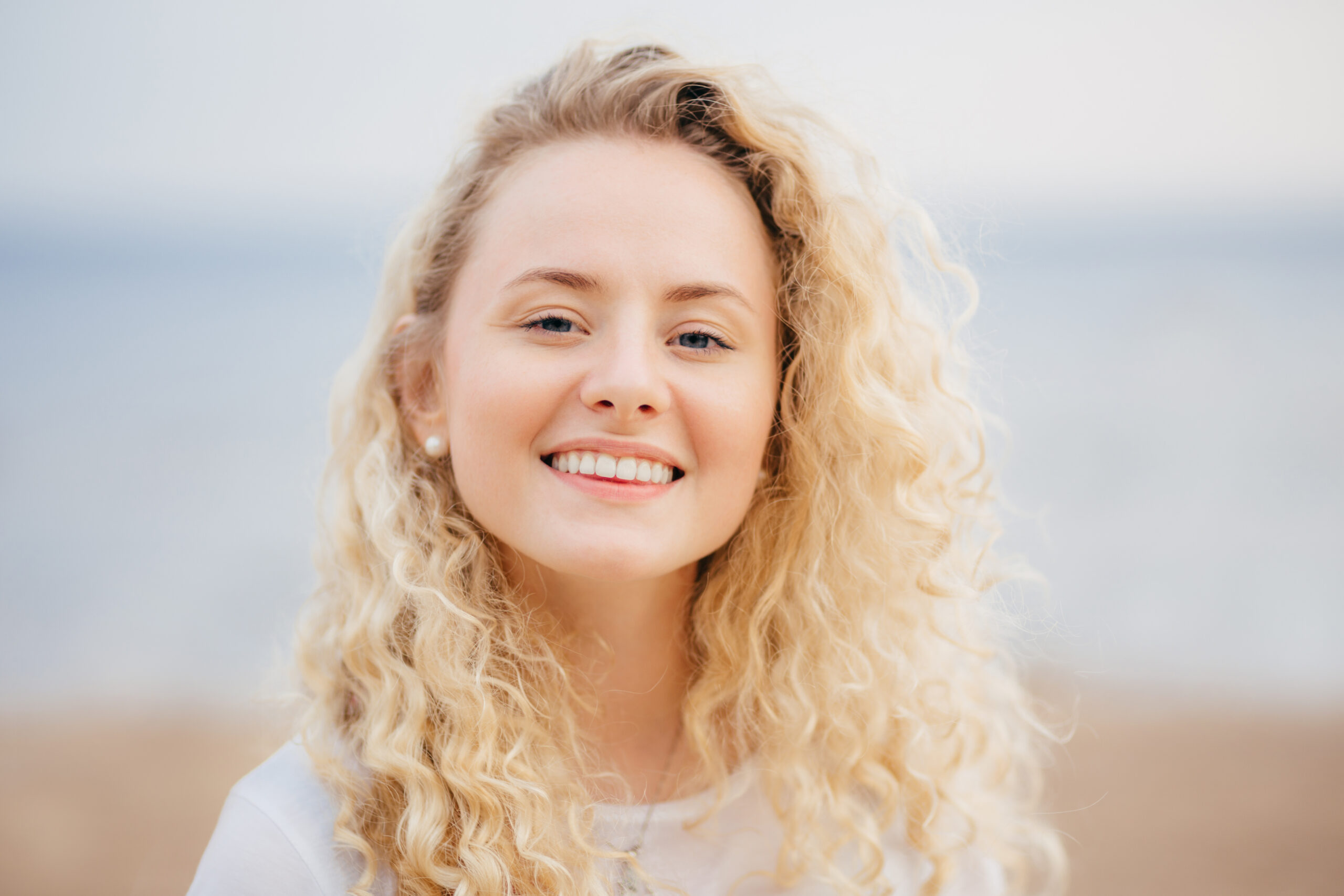 Headshot of beautiful woman with friendly smile, has healthy skin